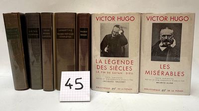 several books are lined up on a white surface with a small number