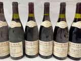 six bouteilles de vin sont alignées sur une table