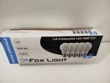 a box of four white light bulbs sitting on top of a table