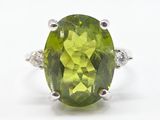 gros plan d'une bague avec une pierre verte entourée de diamants