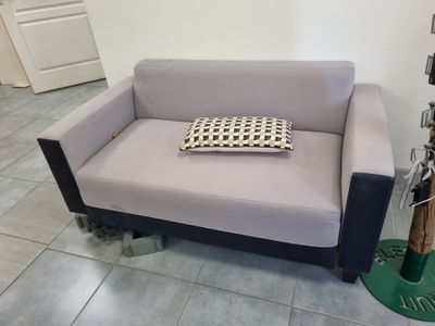 un canapé gris avec un coussin dessus, dans une pièce
