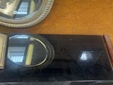a black counter top with a mirror and a clock on it