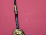 a close up of a sword on a table with a red cloth