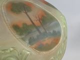 a green vase with a picture of a tree on it