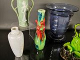 several vases are sitting on a black table with a silver tray