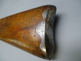 an old wooden knife with a metal handle on a white surface