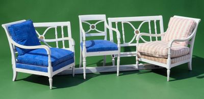 three white chairs with blue cushions on them against a green background