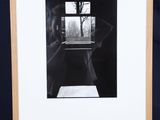 a black and white photo of a person standing in front of a painting
