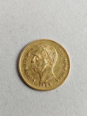 a close up of a gold coin on a white surface