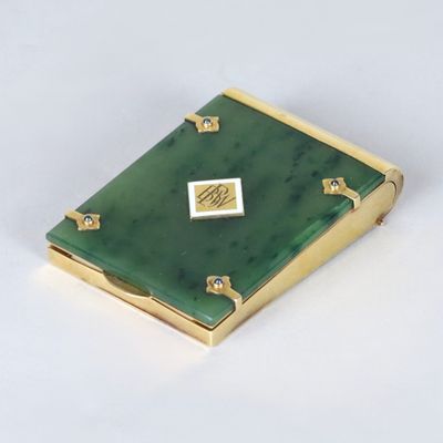 broche en forme de livre, de couleur or et verte, ornée d'un diamant au centre