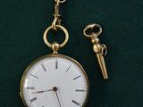 une montre de poche en or à laquelle est attachée une chaîne
