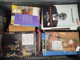 plusieurs livres superposés dans une boîte
