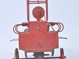 a red toy car that is sitting on a white surface