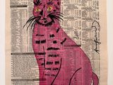a pink cat sitting on top of a newspaper