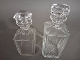 pair of clear glass perfume bottles on a gray surface