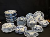 blue and white china plates and bowls on a black table