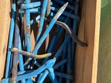 une boîte en bois remplie de clous et des clous par terre