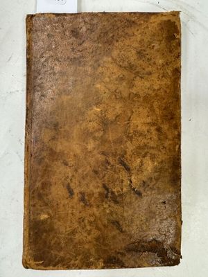 un vieux livre posé sur une table, à côté d'une étiquette
