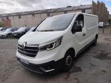 la camionnette blanche est garée dans un parking près d'un bâtiment