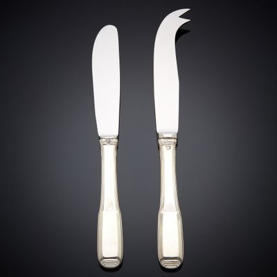 a pair of silver plated cheese knives on a black background