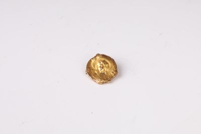 gros plan d'une pièce d'or sur une surface blanche