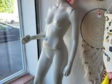 a mannequin wearing a pink hat next to a window