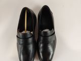 a pair of black leather shoes on a white surface