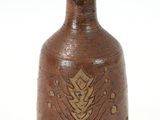a brown vase with a gold leaf design on it
