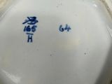 an image of a white and blue vase sitting on top of a table