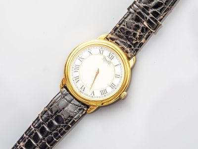 une image représentant une montre dorée et noire avec des chiffres romains
