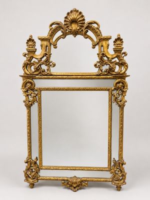 un miroir à cadre doré orné d'un motif représentant un oiseau et une fleur