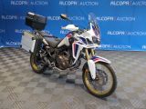 une moto blanche et bleue garée sur un sol à damier