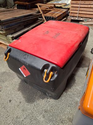a suitcase that is sitting on the ground next to a pile of wood