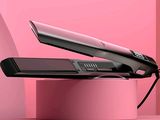 un sèche-cheveux posé sur une boîte rose