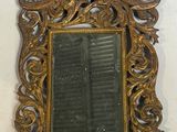 un miroir accroché au mur avec un cadre doré