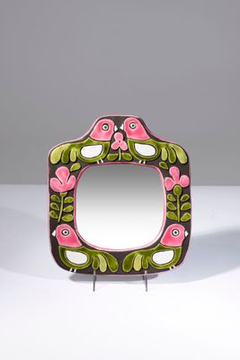 un gros plan d'un miroir posé sur une table, sur lequel se trouve un oiseau