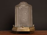 a glass lamp that is sitting on a wooden table