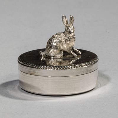 a silver rabbit sitting on top of a silver box