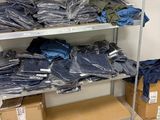 beaucoup de chemises bleues sur une étagère dans une pièce