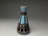 un vase bleu et noir posé sur une table