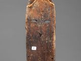 an old wooden mask with a small face on it