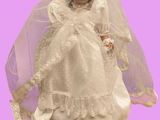une poupée qui porte une robe de mariée et un voile