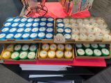 many candles that are in boxes on the table