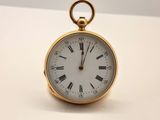 une montre de poche en or avec des chiffres romains sur le cadran