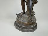a statue of a man holding a fish on a pedestal