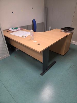 un bureau en bois avec une chaise bleue dans un coin de la pièce