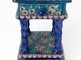 une image représentant une petite table bleue sur laquelle sont disposées des fleurs