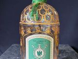 a bottle of liquor with a green ribbon on top of it