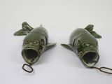 two green fish shaped objects on a white surface