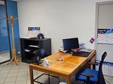 une pièce équipée d'un bureau, d'une chaise et d'un ordinateur